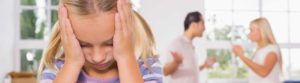 young girl covering ears while parents arguing in background The Webster Law Firm
